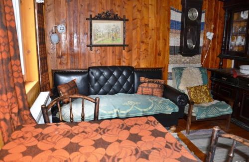 ein Wohnzimmer mit einem Ledersofa und einem Stuhl in der Unterkunft Chata U skřítka in Valašská Bystřice