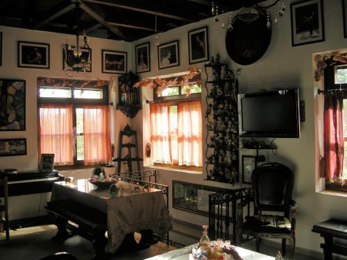 ein Wohnzimmer mit einem TV und einem Tisch in der Unterkunft Kria springs in Livadia