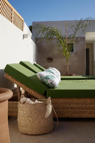a bedroom with a green bed and a basket at Numa Marrakech in Marrakech