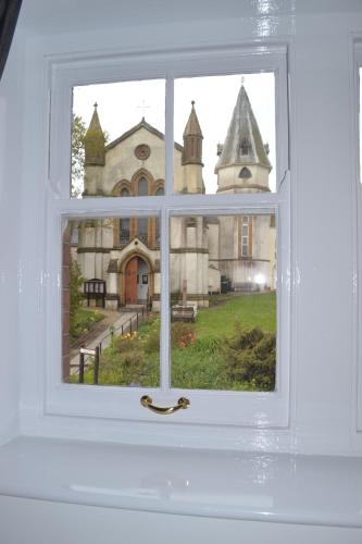 a window with a view of a church at The Nags Head - Room only accommodation in Lyme Regis