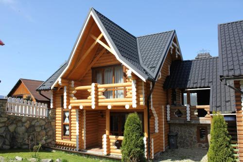 una casa de madera con techo negro en Oberig Apartmens, en Vorokhta