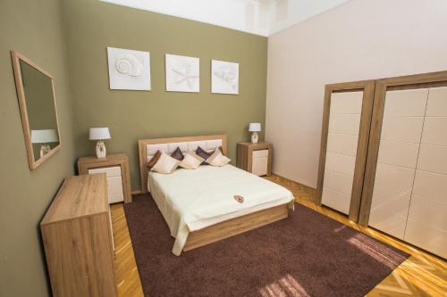 セゲドにあるNovák apartman Szegedのベッドルーム1室(ベッド1台、ナイトスタンド2台、鏡付)