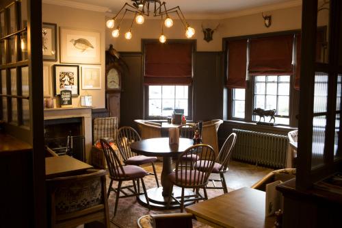 a dining room with tables and chairs and windows at Wynnstay Arms, Ruabon, Wrexham in Ruabon