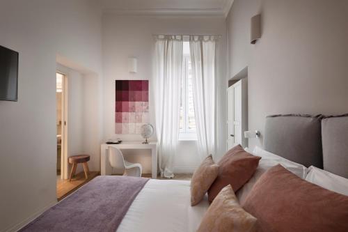 a bedroom with a bed and a desk with a window at DA ME Suites in Rome