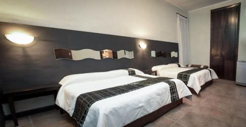 una habitación de hotel con 2 camas y una pared negra en Samsara Hotel Salta en Salta