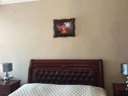 a bedroom with a bed and a picture on the wall at Guest House kartvelishvili in Batumi