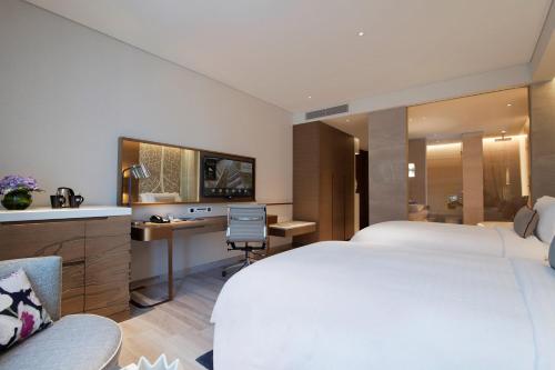 a hotel room with a large bed and a desk at Al Bandar Rotana – Dubai Creek in Dubai