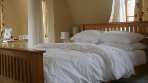 a bedroom with a bed with white sheets and pillows at The Keep in Ludlow
