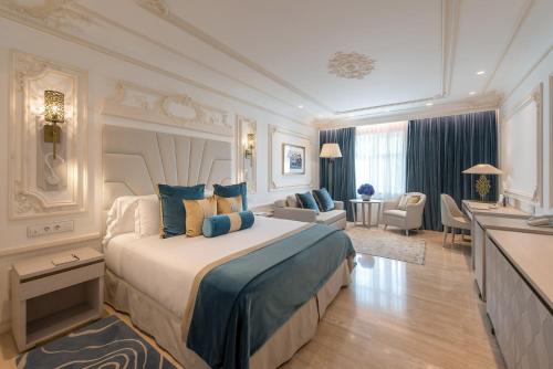 Un dormitorio con una cama grande y una sala de estar. en Gran Hotel Miramar GL, en Málaga