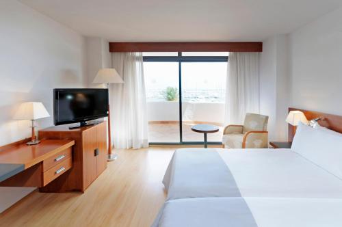 a hotel room with a television and a bed at Hotel Palma Bellver , Affiliated by Meliá in Palma de Mallorca