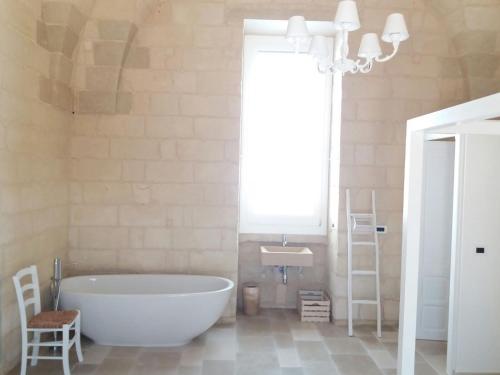 baño con bañera grande y lavamanos en Masseria "Casa Giulia", en Uggiano la Chiesa