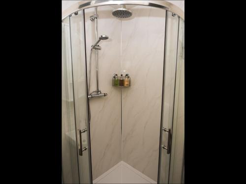 a shower with a glass door in a bathroom at Cedar Apartment in Helensburgh