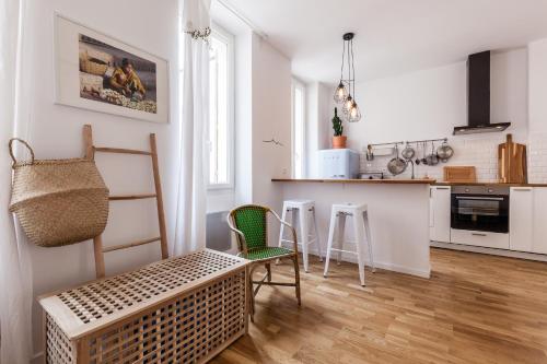 une cuisine avec des armoires blanches et une table et des chaises dans l'établissement 5 Sens, à Marseille