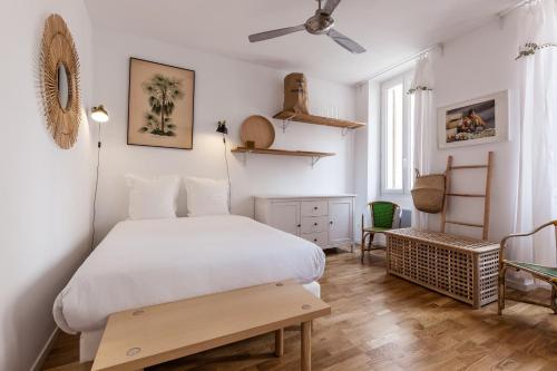 une chambre avec un lit blanc et une table dans l'établissement 5 Sens, à Marseille