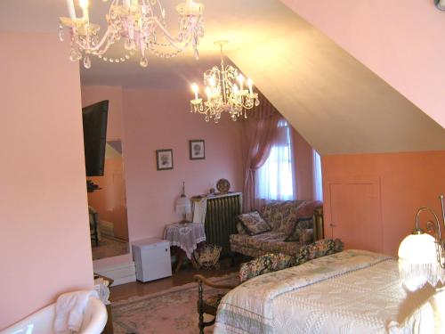 a living room with a bed and a chandelier at Wakamow Heights Bed and Breakfast in Moose Jaw