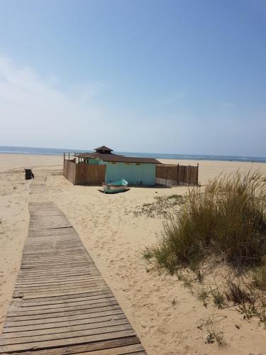a wooden path on a beach with a building at Sol y Sombra Apartamento con entrada independiente in Isla del Moral