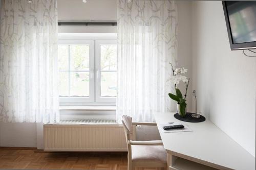 a white room with a table and a window at Schwanenhof Hotel und Restaurant in Erkelenz