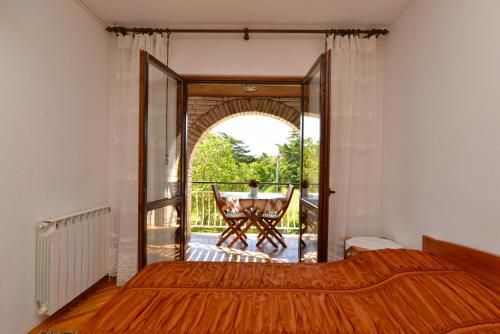 a bedroom with a bed and a table on a balcony at Apartment & room Milka 1633 in Pula