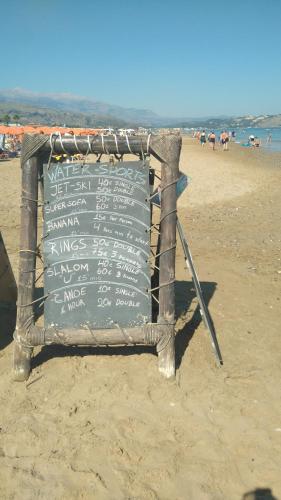 a sign on the beach with people in the water at 360 Panorama House - Gazing at Horizon and the Stars of the Galaxy in the night - Fresh Cool breeze most of the time - just 7 min from the beach in Kournás