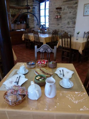 une table dressée avec de la vaisselle et des plats dans l'établissement Hotel Rural Molino del Arriero, à Luyego de Somoza