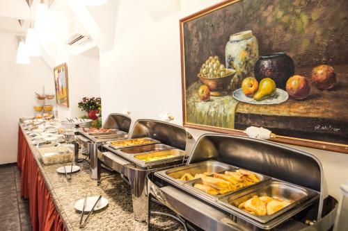 a buffet line with a bunch of trays of food at Monika Centrum Hotels in Rīga