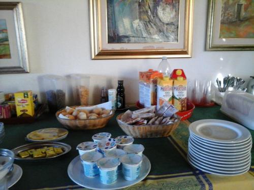 a table with plates and baskets of food on it at Affittacamere Valverde di Naitana Rita in Alghero