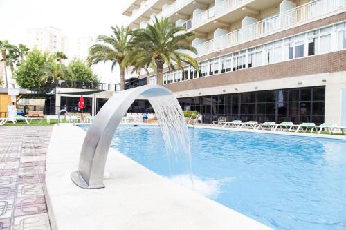 a fountain in a pool in front of a building at Hotel Joya in Benidorm