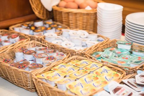 a table with baskets of pastries and plates and eggs at Hotel Primo in Riva del Garda