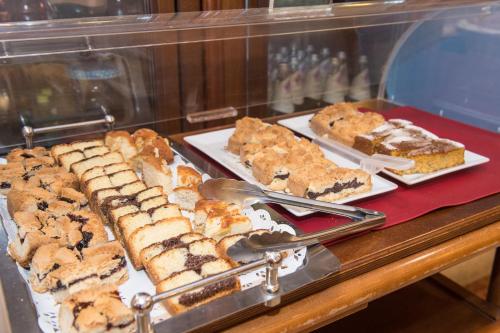 a display case with different types of cakes and pastries at Hotel Primo in Riva del Garda