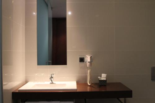 baño con lavabo y teléfono en Lazza Hotel, en Figueira da Foz