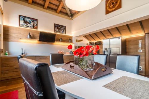 a dining room with a table with red flowers on it at La Loggia Al Duomo - Treviso in Treviso
