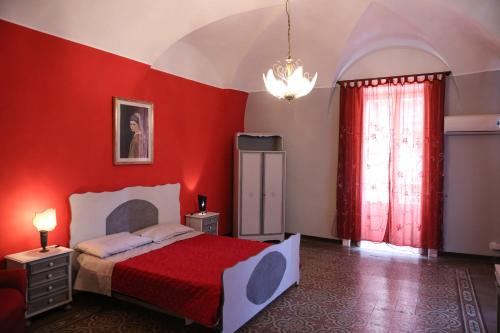 Un dormitorio con una pared roja y una cama. en la locanda del centro storico, en Catania