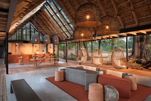 una gran sala de estar con sillas y mesa. en Lion Sands River Lodge en Sabi Sand Game Reserve