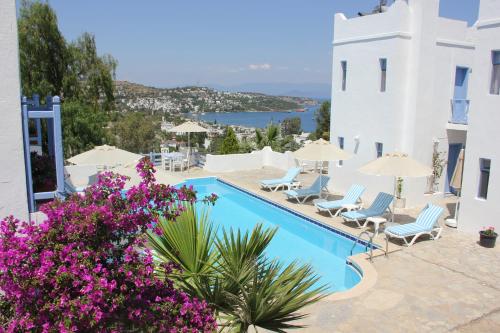 vistas a una piscina con sillas y flores en Panorama Hotel Bodrum, en Golturkbuku