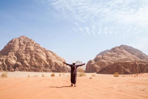 a man standing in the desert with his arms outstretched at Arabian Nights in Wadi Rum
