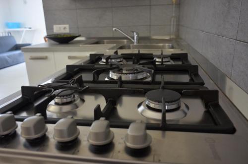 a kitchen with a stove top with a sink at Villa Sangemi in Àrbatax