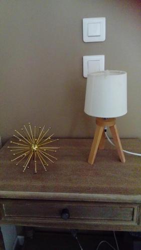 a lamp on top of a table with a candle on it at Le Compostelle de Conques in Conques-en-Rouergue