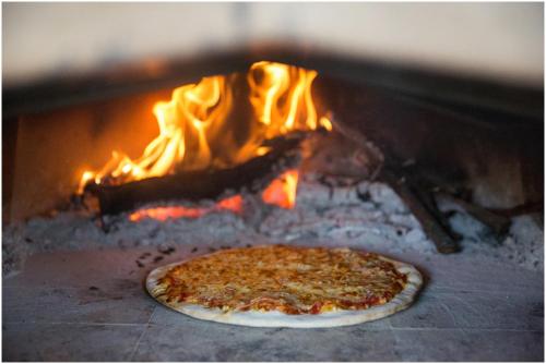 a pizza is cooking in a fire oven at House Mellifera in Razvođe