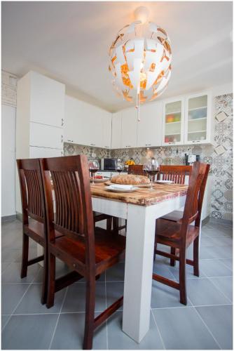 a kitchen with a table with chairs and a chandelier at House Mellifera in Razvođe