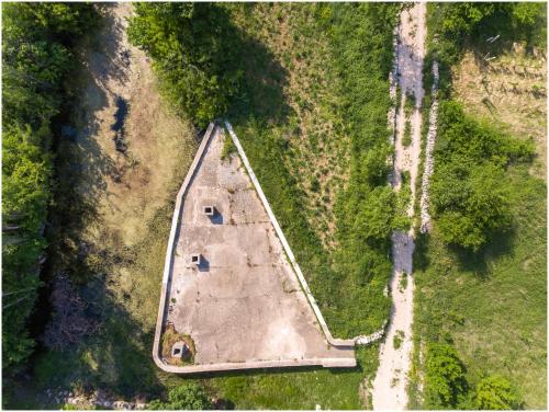 an aerial view of an old building in a field at House Mellifera in Razvođe