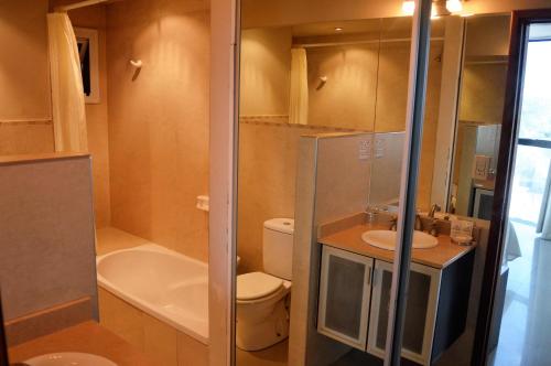 a small bathroom with a toilet and a sink at Apart Riviera Tower Suites in Villa Carlos Paz