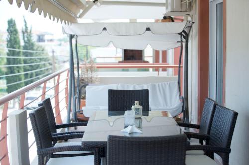 a table and chairs on a balcony with a window at Elena Luxury Apartment in Keramotí