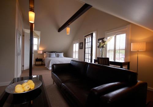 a living room with a couch and a bed at Hotel Les Trois Soeurs in Perce