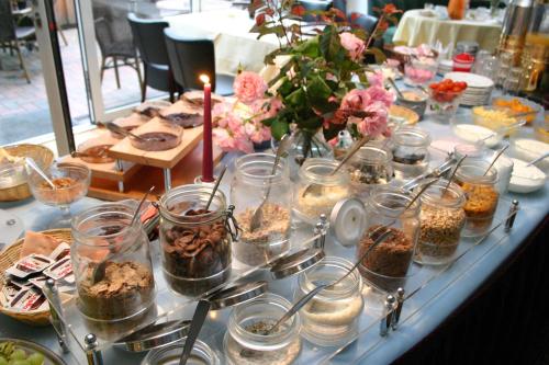 a long table with many jars of food and flowers at Gasthof Oldenwöhrden in Wöhrden