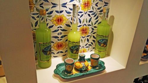 那不勒斯阿格拉米勒公寓的架子上放着四瓶饮料，托盘上放着一盘饮料。