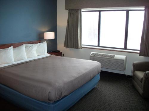 a hotel room with a large bed and a window at AmericInn by Wyndham Beulah in Beulah