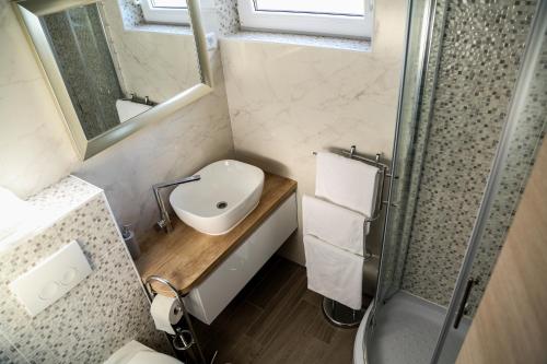 a small bathroom with a sink and a shower at Apartments Sunset in Hvar