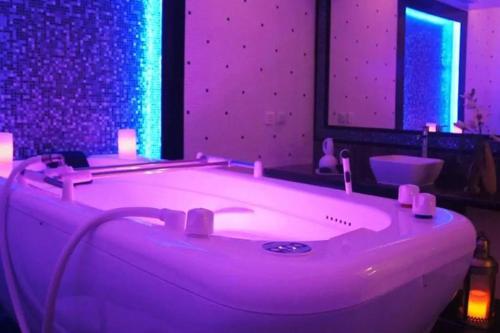 a purple bathroom with a tub with a sink at Residence Folla in Sousse