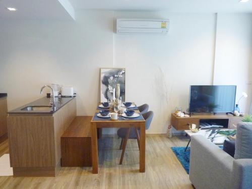 a living room with a table and a couch at Rain Cha-am Huahin By Sake in Cha Am