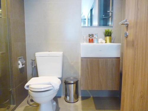 a bathroom with a white toilet and a sink at Rain Cha-am Huahin By Sake in Cha Am